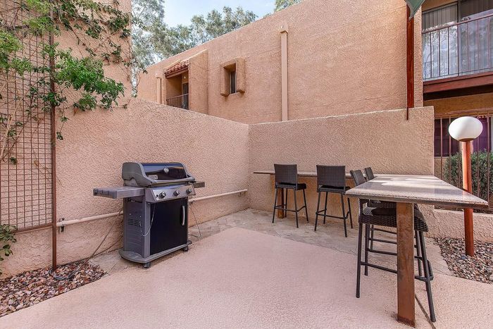 Charming outdoor barbecue area with a modern grill and stylish bar seating, ideal for entertaining.