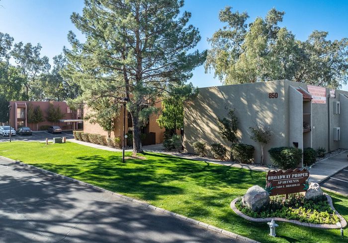 Inviting apartment complex with charming architecture, nestled among lush greenery and vibrant landscaping.