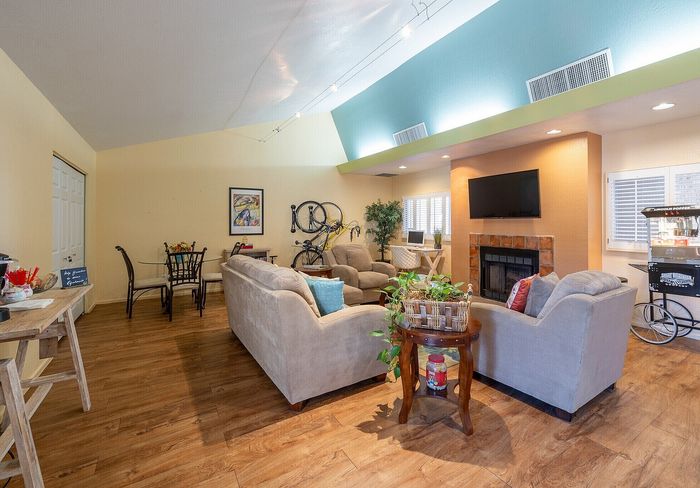 Bright and inviting living room with elegant wooden floors, cozy seating area, modern fireplace, and cheerful decor creating a perfect blend of comfort and style.