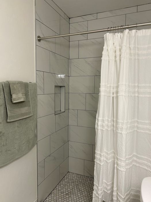 Elegant bathroom with modern subway tiles, a luxurious shower curtain, and plush towels creating a spa-like ambiance.