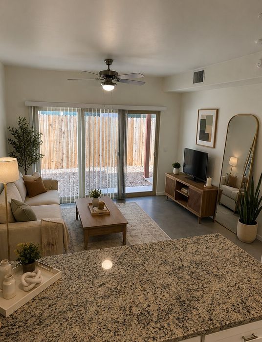 Inviting living area with modern decor, large windows, stylish sofa, and elegant coffee table, perfect for relaxing or entertaining.
