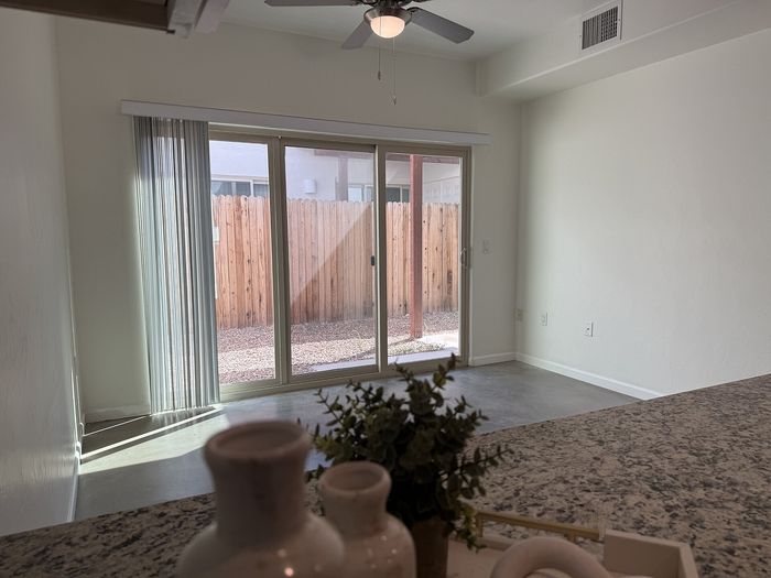 Bright and inviting living area featuring large sliding doors, elegant ceiling fan, and a seamless connection to the outdoor space.