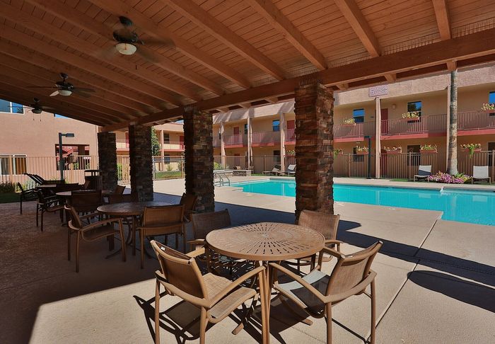 Inviting poolside area with shaded seating and a sparkling outdoor pool, perfect for relaxation and social gatherings.