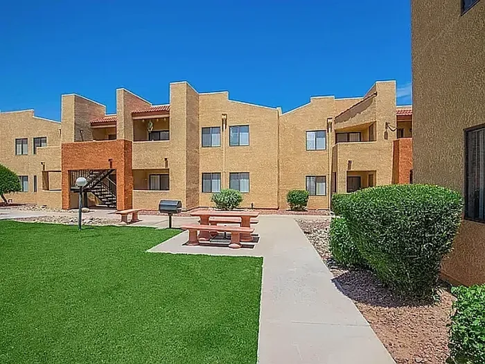 Charming apartment complex with modern architecture, featuring spacious balconies and surrounded by lush greenery.