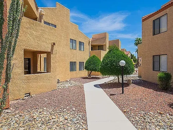 Charming apartment complex with modern architecture, featuring spacious balconies and surrounded by lush greenery.