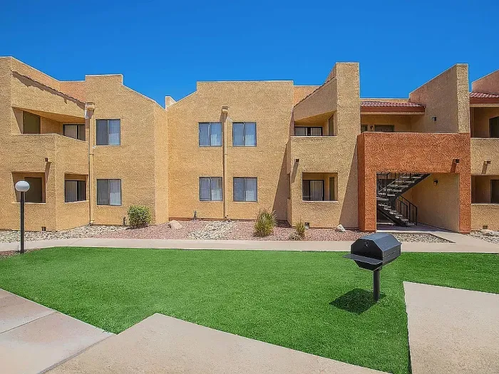 Charming apartment complex with modern architecture, featuring spacious balconies and surrounded by lush greenery.