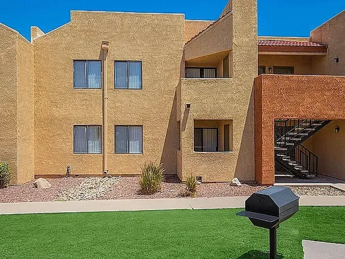 Charming apartment complex with modern architecture, featuring spacious balconies and surrounded by lush greenery.