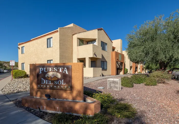 Charming apartment complex with modern architecture, featuring spacious balconies and surrounded by lush greenery.