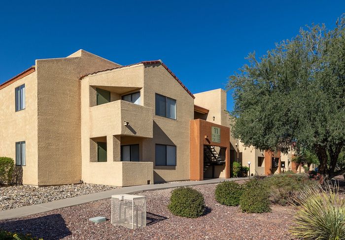 Charming apartment complex with modern architecture, featuring spacious balconies and surrounded by lush greenery.