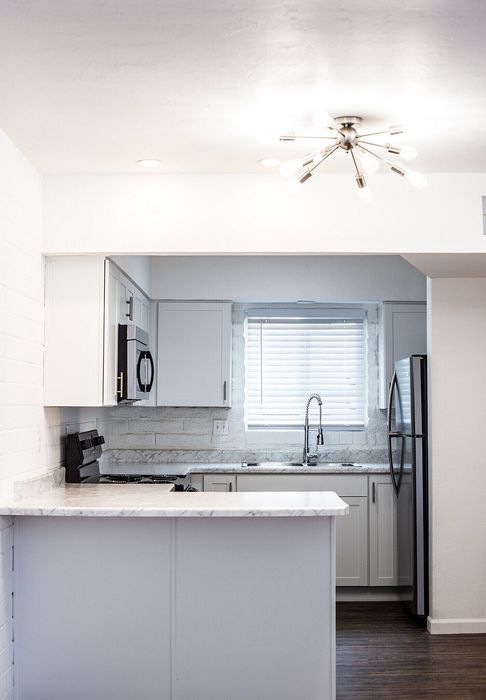 Modern kitchen with sleek white cabinetry, stainless steel appliances, and elegant lighting, showcasing a bright and inviting space.