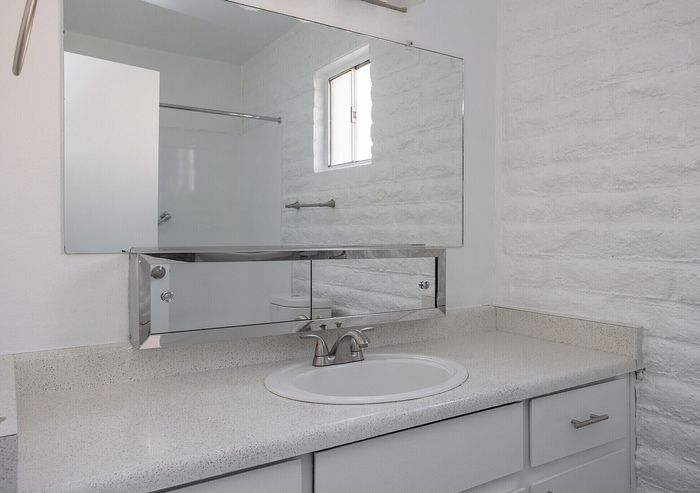 Bright and modern bathroom featuring a sleek vanity, elegant mirrored cabinet, and contemporary fixtures.