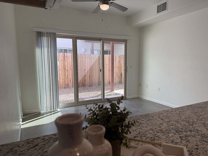 Bright and inviting living area with large sliding glass doors opening to a private patio, perfect for indoor-outdoor living.