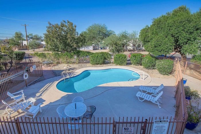 Inviting outdoor pool area with comfortable lounge chairs and lush greenery, perfect for relaxation and enjoyment.