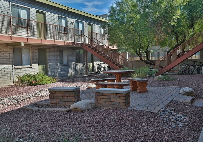Charming courtyard with modern brick seating area and lush greenery, ideal for relaxation and outdoor gatherings.