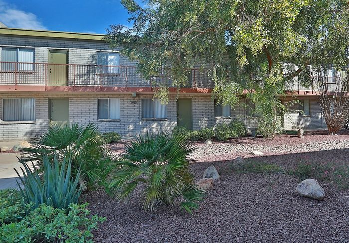 Charming apartment building with lush landscaping and a tranquil courtyard, offering a serene living experience.