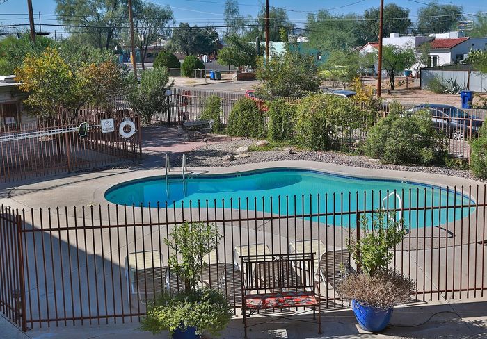 Inviting outdoor pool area surrounded by lush greenery, perfect for relaxation and leisure in a serene residential community.