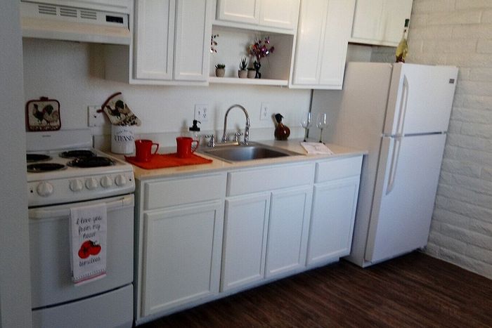 Charming and bright kitchen with sleek white cabinetry, modern appliances, and elegant decor accents.