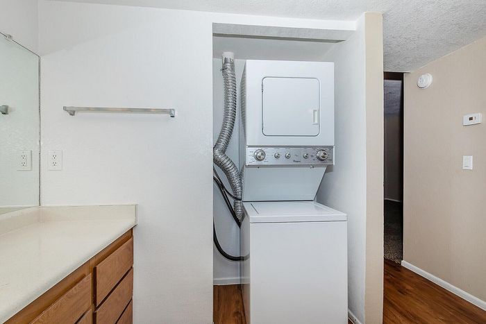 Modern laundry space with a sleek stacked washer and dryer set in a bright, minimalist room.