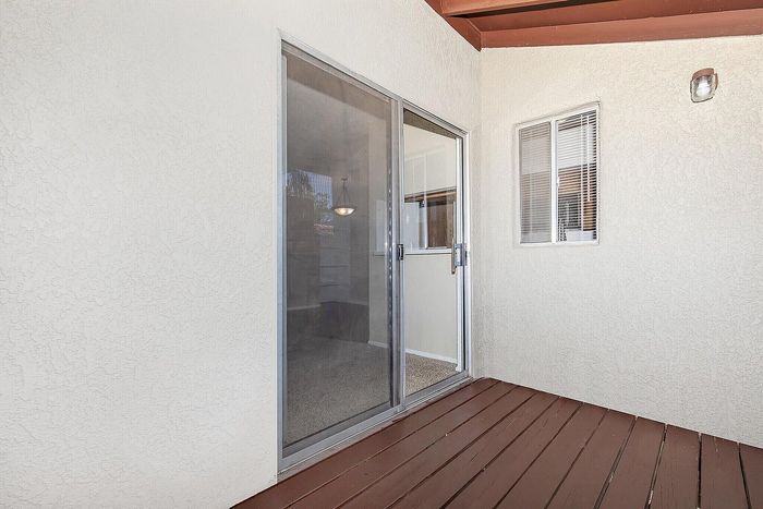 Charming private balcony with sliding glass door, inviting natural light and fresh air indoors.