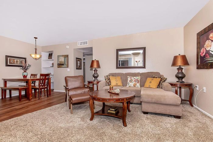 Charming living and dining area featuring plush sofas, elegant wooden furniture, and warm lighting, creating a cozy and inviting ambiance.