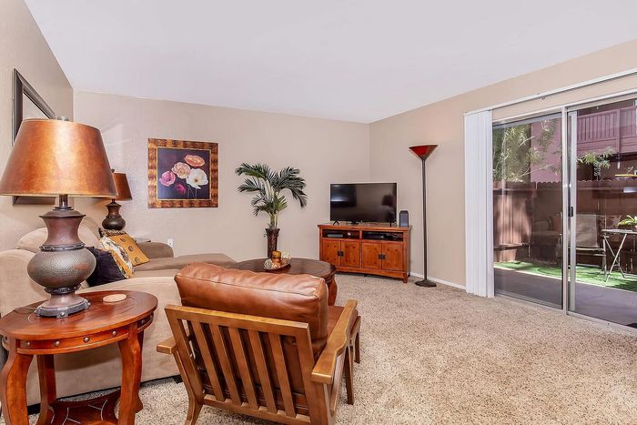 Inviting living room with cozy seating, modern decor, and abundant natural light from sliding glass doors leading to a lush outdoor space.