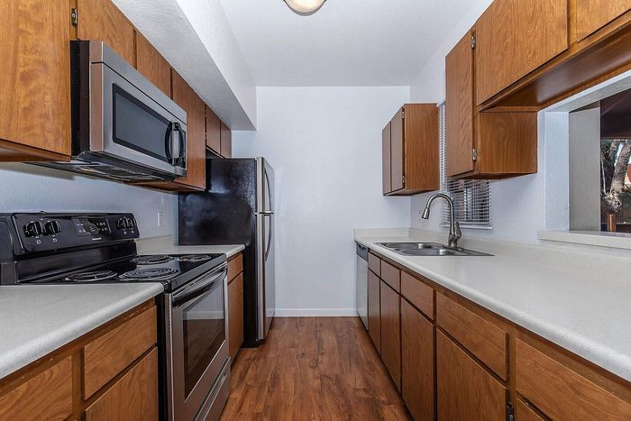 Modern kitchen with sleek appliances, wood cabinetry, and stylish countertops.