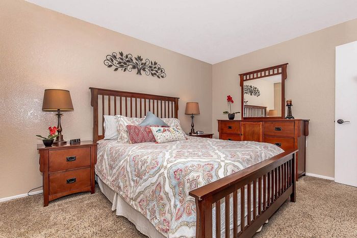Inviting bedroom with elegant wooden furniture, plush bedding, and warm lighting, ideal for relaxation and comfort.