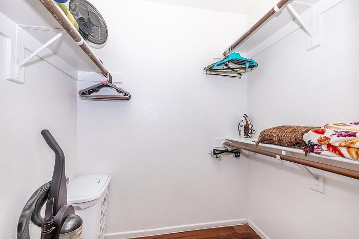 Spacious walk-in closet with ample shelving and storage options, featuring bright lighting and organized layout.