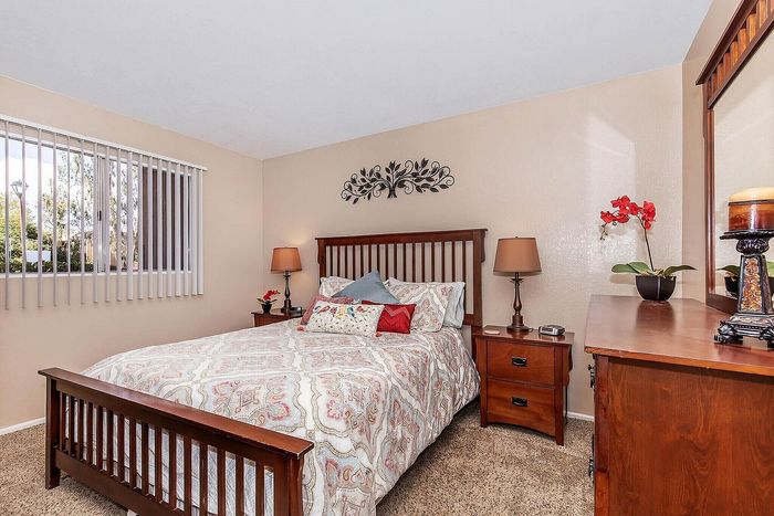 Elegant bedroom with warm wood furniture, cozy bedding, and decorative accents, ideal for relaxation and comfort.