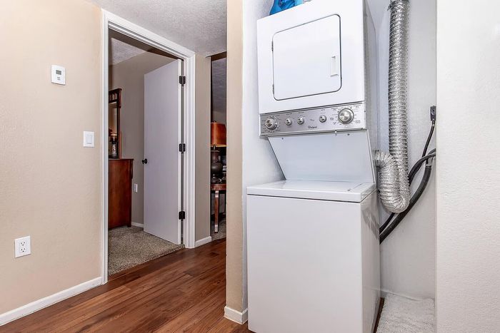 Modern apartment hallway featuring a built-in washer and dryer, showcasing convenience and functionality.