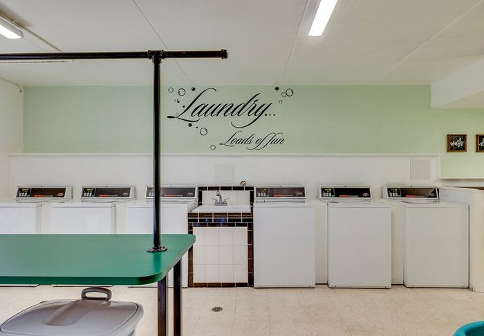 Bright and inviting laundry room featuring modern washing machines and cheerful decor with the phrase 'Laundry... Loads of fun.'