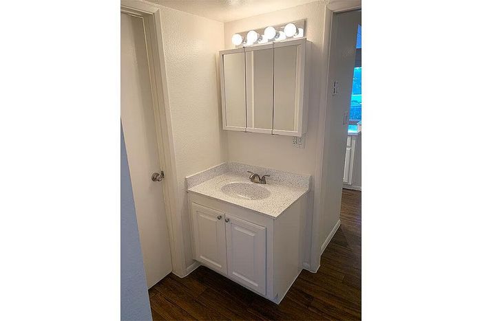 Chic bathroom vanity area with sleek white cabinetry and modern lighting.