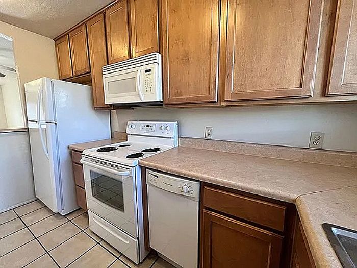 Charming kitchen with modern appliances, ample wooden cabinetry, and elegant countertops.