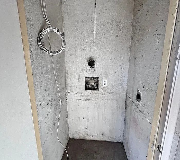 Cozy nook in apartment showcasing potential for customization with utility hookups, ready for transformation into a functional laundry or storage area.