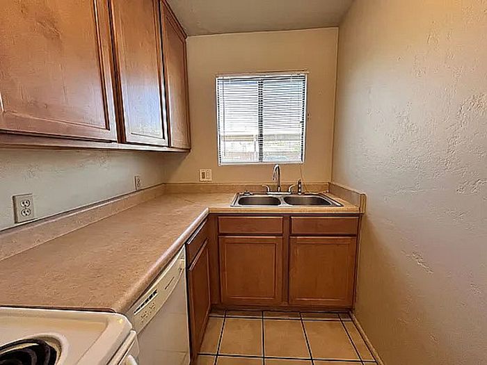 Charming kitchen nook featuring warm wooden cabinets, elegant countertops, and a large window inviting natural light.