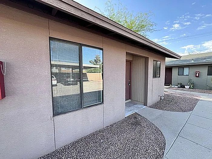 Charming single-level home with a welcoming entrance, large windows, and an inviting outdoor pathway.