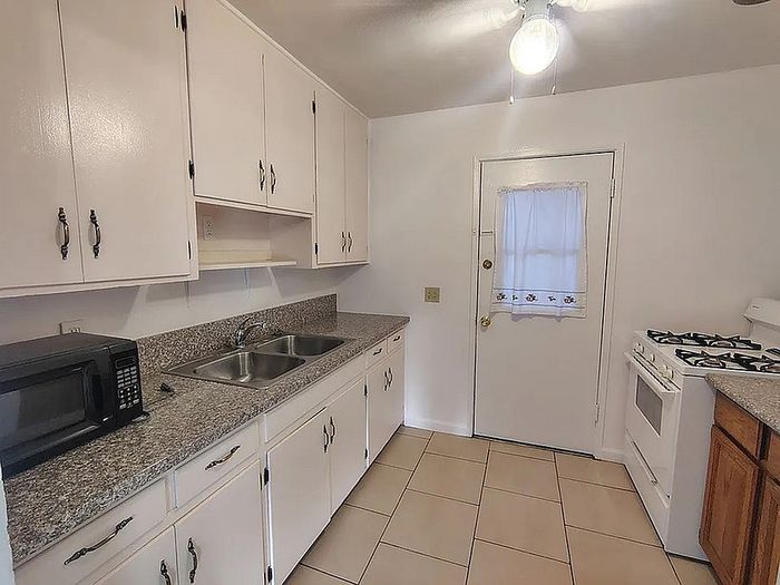 Bright and inviting kitchen with modern appliances, sleek granite countertops, and ample storage in white cabinetry.