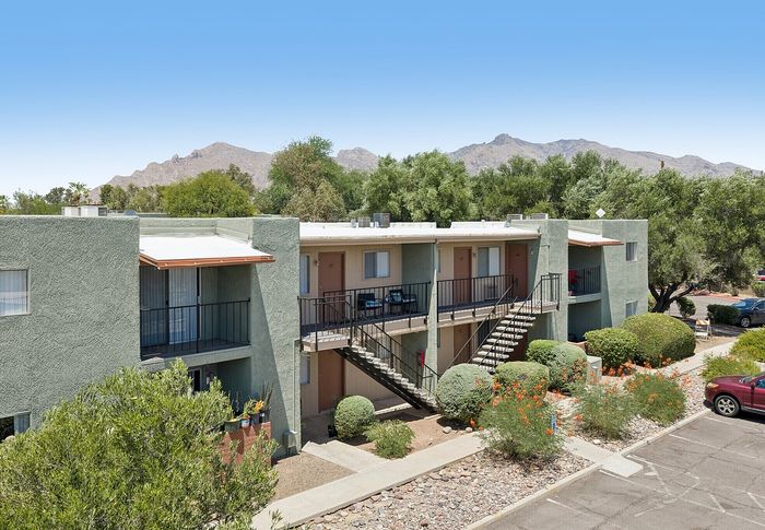 Charming apartment building with lush landscaping and stunning mountain views, offering a serene living environment.