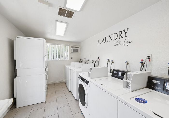 Bright and spacious communal laundry room with modern washers and dryers, designed for convenience and efficiency.