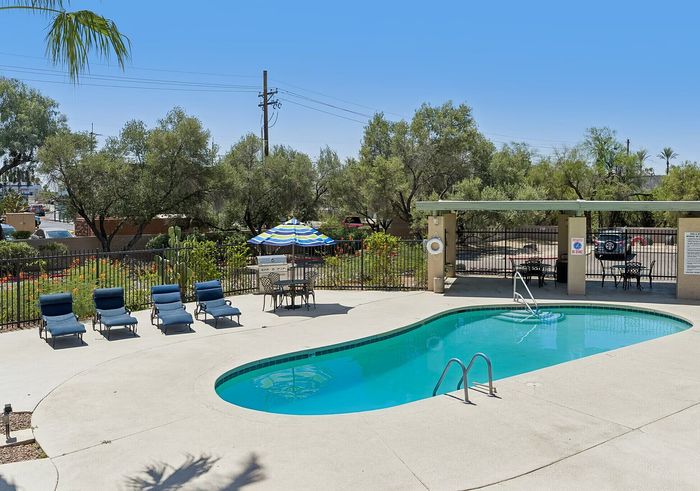 Inviting outdoor pool area with comfortable lounge chairs and shaded seating, perfect for relaxation and leisure.