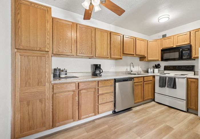 Inviting kitchen with modern appliances, wooden cabinetry, and sleek countertops, perfect for culinary enthusiasts.