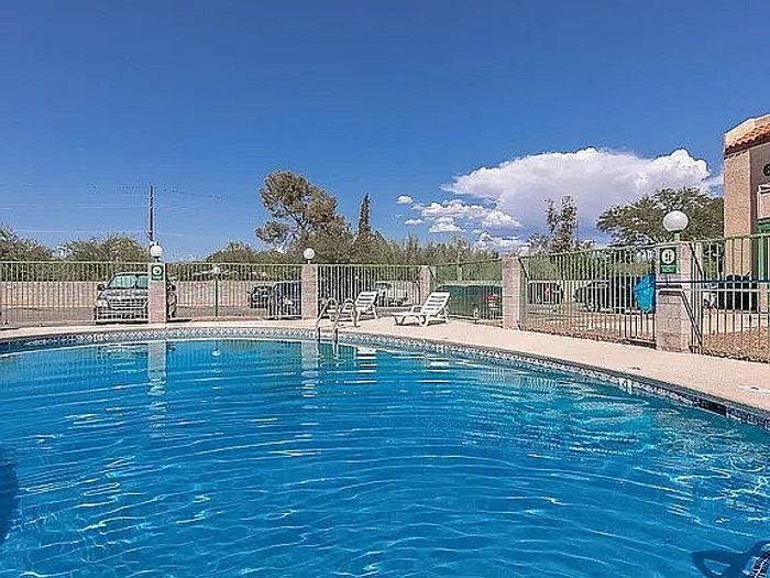 Inviting outdoor pool area with lounge chairs, perfect for relaxation under the clear blue sky.