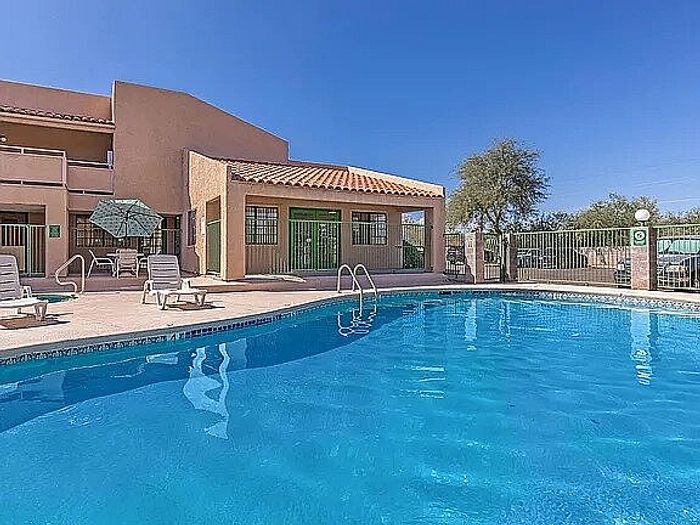 Inviting outdoor swimming pool area with sun loungers and umbrellas, perfect for relaxation and leisure.