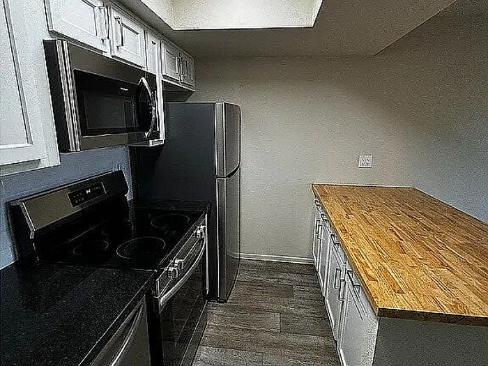 Modern kitchen with sleek stainless steel appliances, elegant wood countertops, and stylish cabinetry.