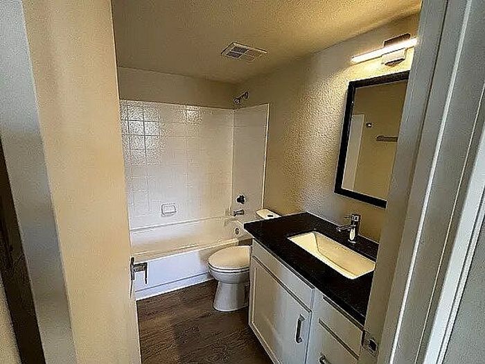 Sleek bathroom featuring a modern vanity, elegant lighting, and a pristine bathtub.