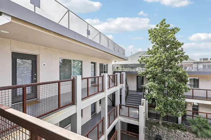 Modern apartment complex with sleek balconies and lush greenery, perfect for urban living.