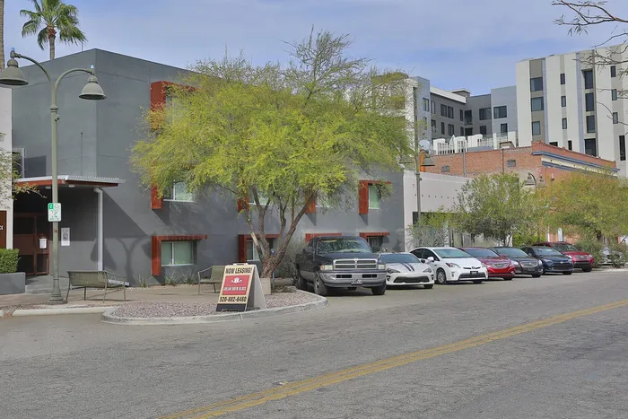 Modern apartment building with sleek exterior design and vibrant surroundings, offering available rental flats and convenient parking.