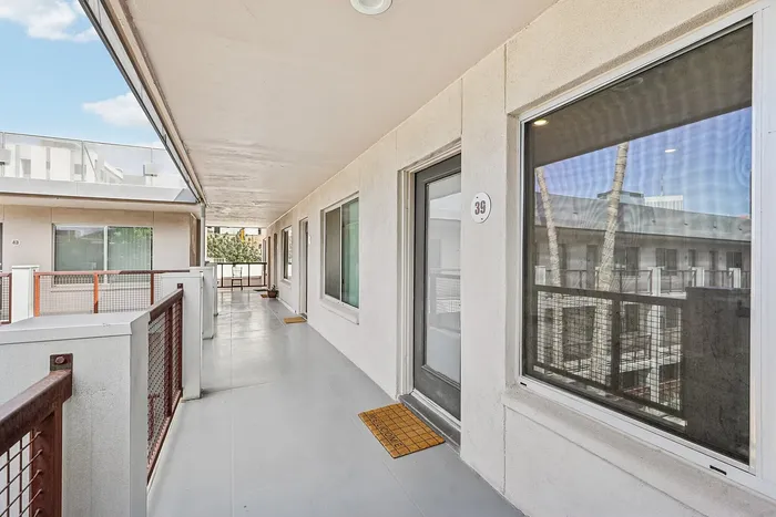 Bright, inviting apartment corridor with modern railings and stylish windows, offering a welcoming atmosphere.