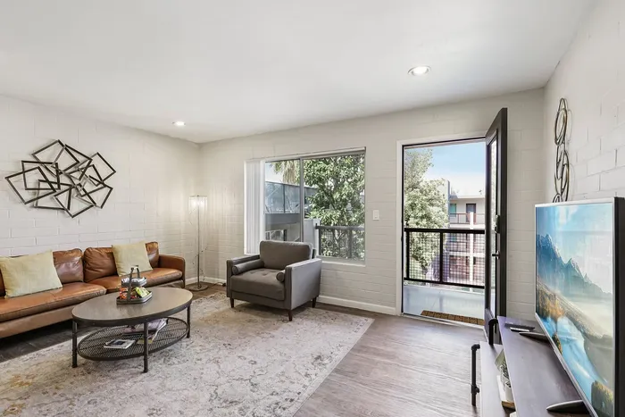 Bright and inviting living room with contemporary decor, cozy seating, and a scenic balcony view.