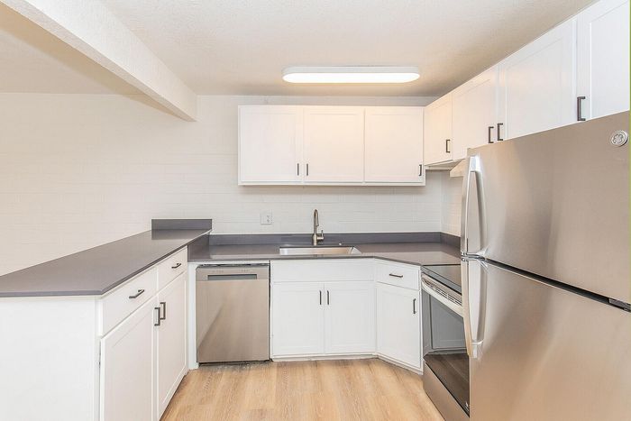 Modern kitchen with sleek stainless steel appliances, elegant white cabinetry, and stylish countertops, perfect for culinary enthusiasts.